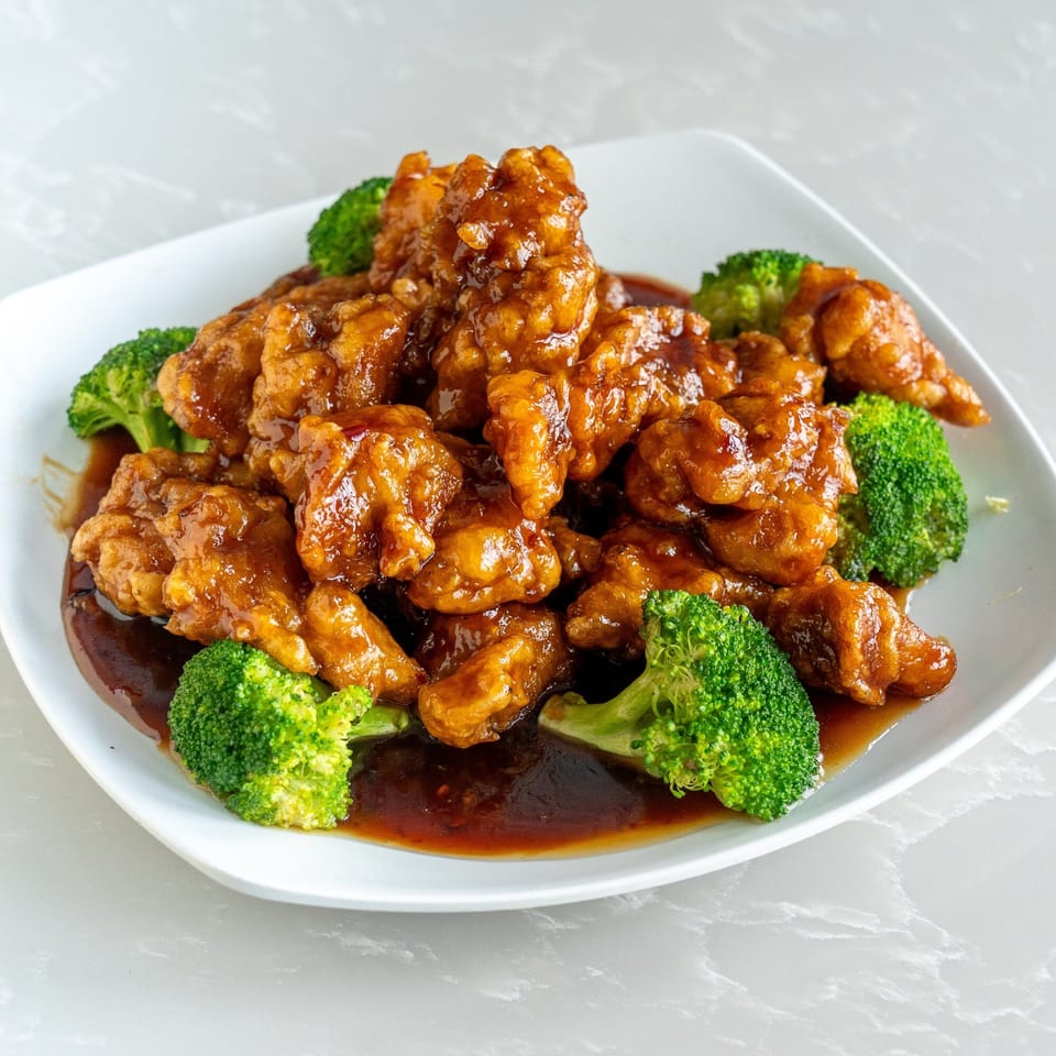 Sharetea Fatty Panda's orange chicken with broccoli florets, coated in a glossy, rich brown sauce.